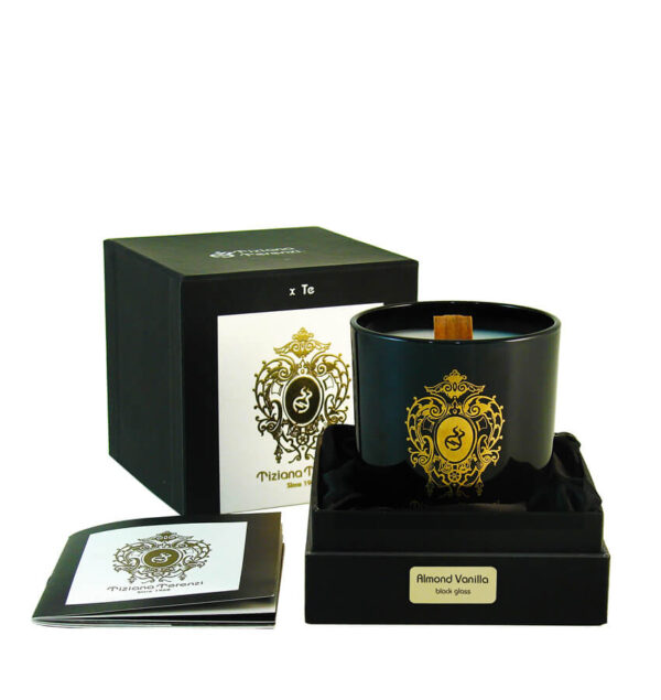 Candela Tiziana Terenzi Almond Vanilla in vaso di vetro nero con stoppino in legno e decorazione dorata. Presentata in una confezione nera elegante, accompagnata da un opuscolo informativo, con il logo distintivo Tiziana Terenzi, artigiani italiani dal 1968.