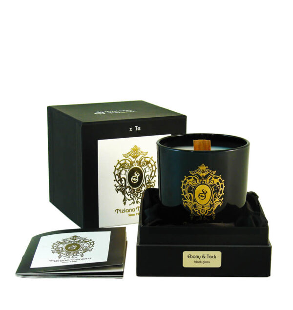 Candela Tiziana Terenzi Ebony & Teck in vaso di vetro nero con stoppino in legno e decorazione dorata. Presentata in una confezione nera elegante, accompagnata da un opuscolo informativo, con il logo distintivo Tiziana Terenzi, artigiani italiani dal 1968.