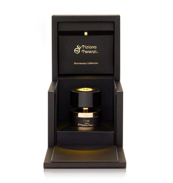 Confezione aperta del profumo 'Hao' della collezione Anniversary di Tiziana Terenzi, con flacone nero e dettagli dorati esposti in un'elegante scatola illuminata.